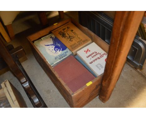 A vintage wooden advertising crate and contents of various old books