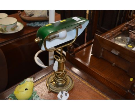 A brass desk lamp with green glass shade
