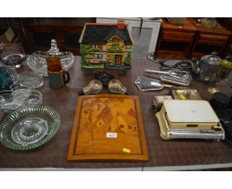 An inlaid wooden plaque depicting a thatched cottage; together with two ships in glass bulbs, a novelty nut cracker and a doo