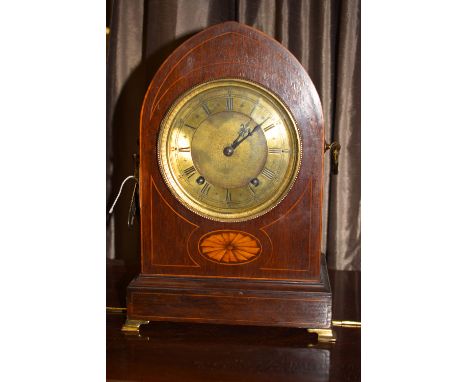 An Edwardian mahogany inlay mantel clock, roman dial with bevelled glass, brass handles and bracket feet, in arched case, sta