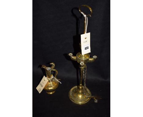 A tall slender Middle Eastern oil lamp with four belts, with attached snuffer and wick trimmer; together with a small near ma