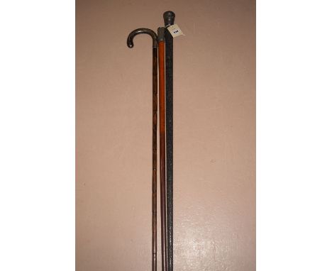 A silver handled walking stick; together with two others with white metal handles, one with carved wooden shaft.