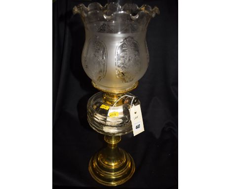 A Victorian brass and glass table oil lamp with later etched shade and clear cut glass reservoir, on brass stand.