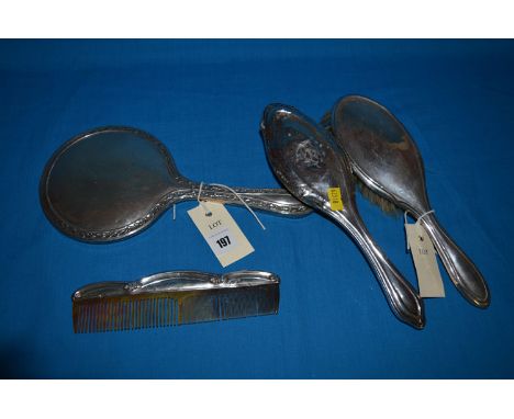 Silver backed dressing table items, to include; a hand mirror; two clothes brushes and a comb.