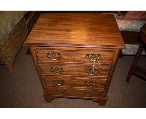 A small Georgian style mahogany chest of four drawers with ornate brass handles and bracket feet, 22in. wide.