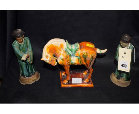 A pair of glazed Chinese ceramic figures of men wearing long robes; and a glazed Chinese figure of a horse.