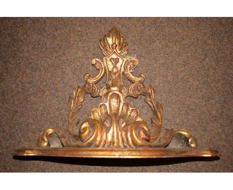 A modern gilt wall bracket/shelf in the rococo style.