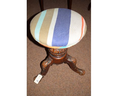 A Victorian circular piano stool with height adjustment on turned and carved boulder support with splayed legs.