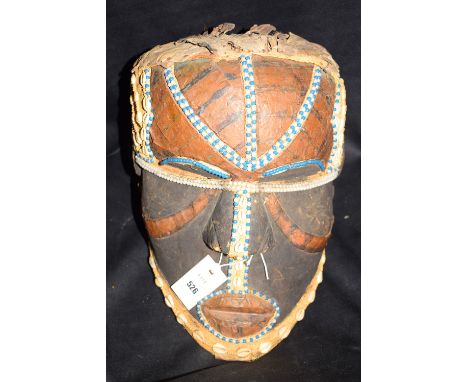 A Kuba Bwoom African helmet/mask, decorated with glass beads and shells.