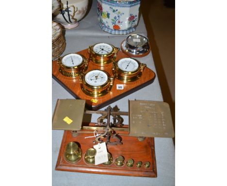 A reproduction weather station, of barometer, hygrometer clock and thermometer on stained wooden plinth; another hygrometer; 