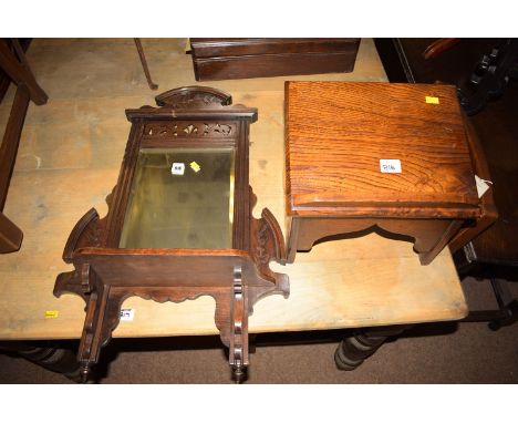A rectangular bevelled wall mirror in carved and stained wood frame, fitted a shelf; together with a small stained elm book s