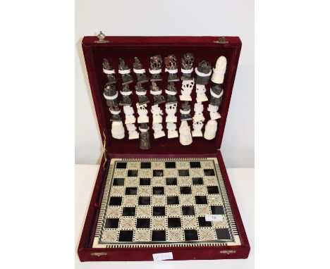 A carved bone chess set with inlaid board 