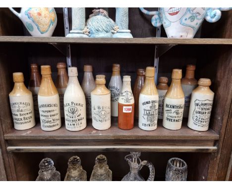 A collection of fourteen Scottish stoneware ginger beer bottles, one with original stoneware threaded stopper; together with 