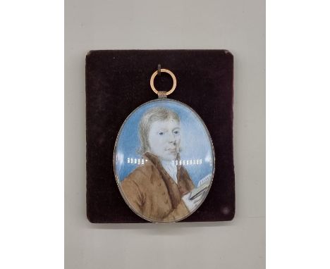 English School,&nbsp;18th century, bust length portrait miniature of a gentleman holding a book, on ivory, 6.5 x 5.3cm oval. 