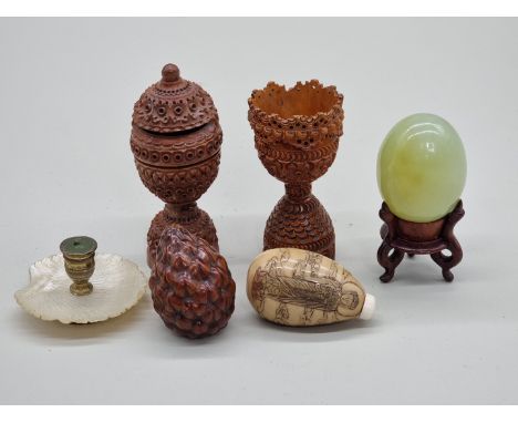 A mixed group of eastern works of art, to include a carved coquilla nut egg cup; a jade egg; a vegetable ivory snuff bottle; 