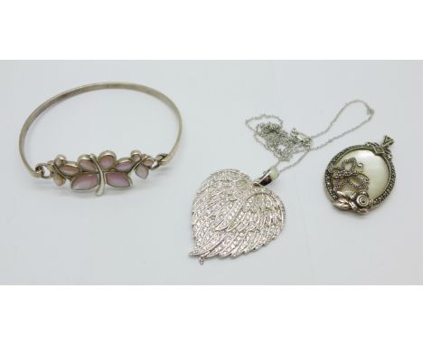 A silver and cubic zirconia pendant and chain, a silver bangle and a mother of pearl and marcasite set pendant 
