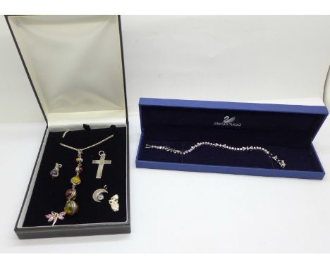 A silver and multi-coloured amber set pendant and chain, a Swarovski bracelet, boxed, and silver charms/pendants 