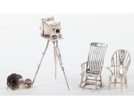 A selection of silver miniatures, including a camera on tripod base, London 925, a silver rocking chair, a silver wheel back 