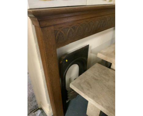 A vintage carved oak fire surround with a small cast fire place