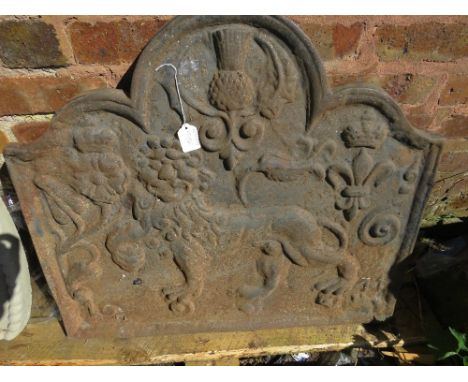 A heavy cast metal fire back with coat of arms style embellishment