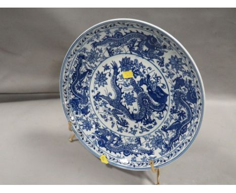 An Oriental blue/white charger decorated with five toed dragons with six character mark to base