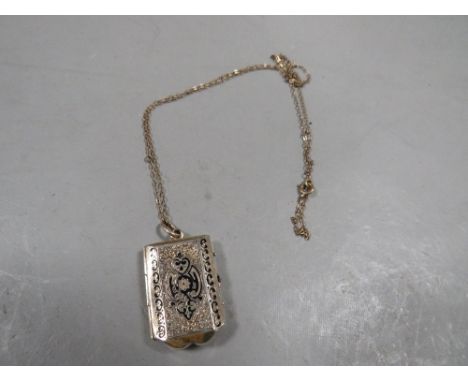 A Victorian antique rolled gold and enamel locket and chain