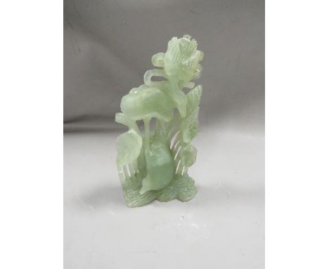 A jade style carved stone figure of birds and fish amongst the lily pads