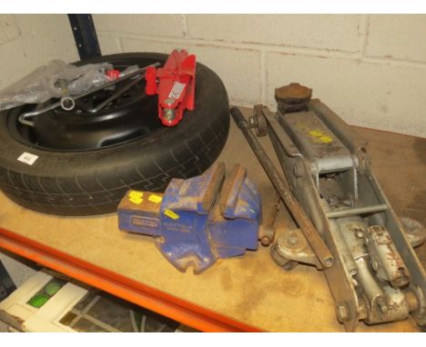 A selection of tools to include a trolley jack, space saver spare wheel and a record vice etc