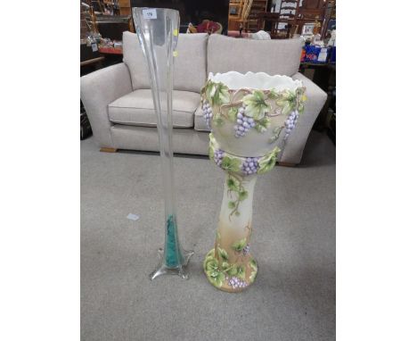 A large ceramic jardinière and stand together with a tall glass vase
