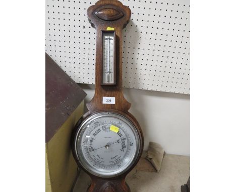 A vintage oak wall mounted barometer