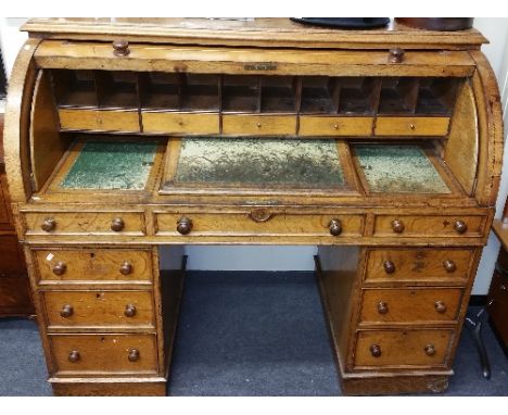 An Early Victorian Oak Cylinder Desk,  with a panelled fall flap, enclosing pigeonholes, drawers and adjustable inset writing