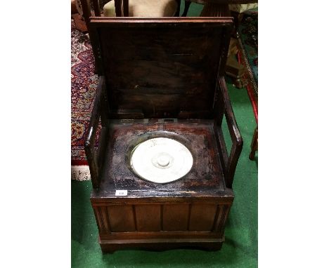 A 19th Century Mahogany Box Commode, the hinged lid with inset carpet panel, the interior with folding rests and original cer