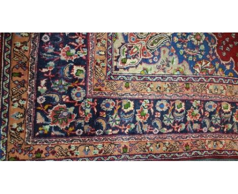 A Large Red Ground Persian Machad Carpet with central medallion and multi borders, 385 x 300.