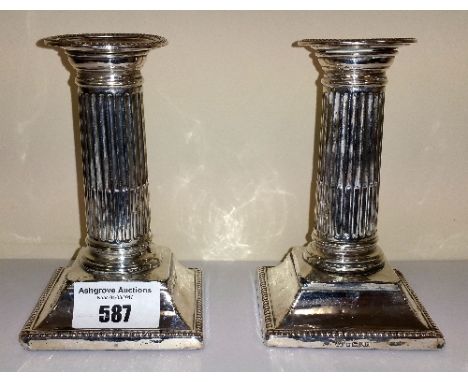 A Pair of Silver Desk Candlesticks, maker Harrison Brothers & Howson, Sheffield 1887, with stop fluted columns on stepped squ