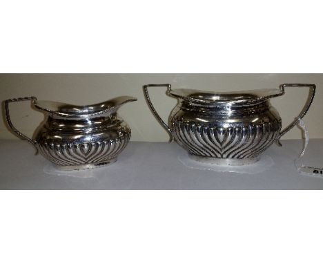 A Silver Cream Jug and Sugar Basin by W. Atkin, Birmingham 1912; of oval gadrooned form, 383g (12.3 troy ozs) gross. 