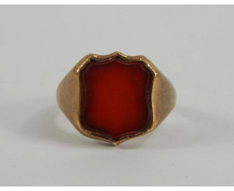 A gentleman's yellow metal and Cornelian set shield shaped signet ring, size R, 9.3g