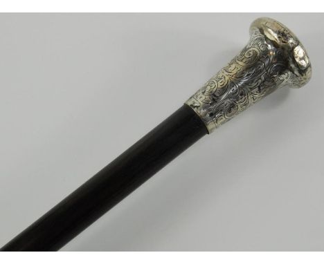 An Edwardian ebony walking stick, with a silver handle, decorated with engraved foliate scrolls, London 1904, 92cm long