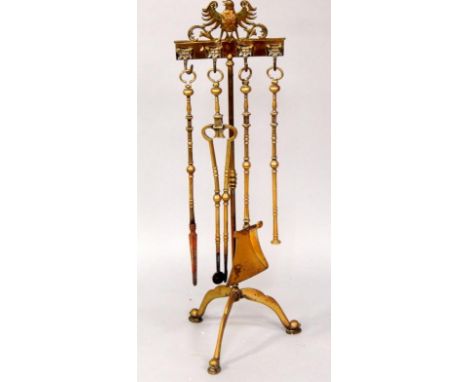 A brass tripod fireside companion set, with tools.