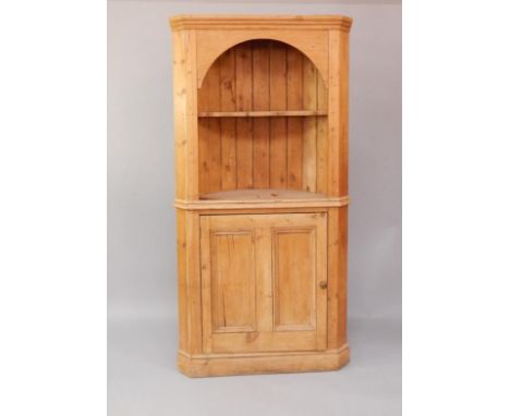 A Victorian pine corner cupboard, the open top revealing a shaped shelf, with a cupboard below, raised on a plinth base, 100c