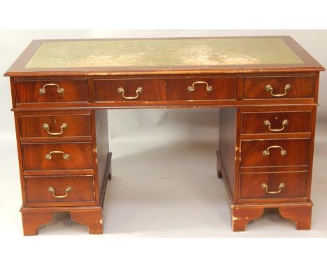 A mahogany twin pedestal desk, the green tooled leather top above one long, six short and one deep drawer, raised on bracket 
