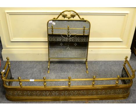 A late 19th century brass fender with pierced flowerhead decoration and a brass framed mirrored firescreen 
