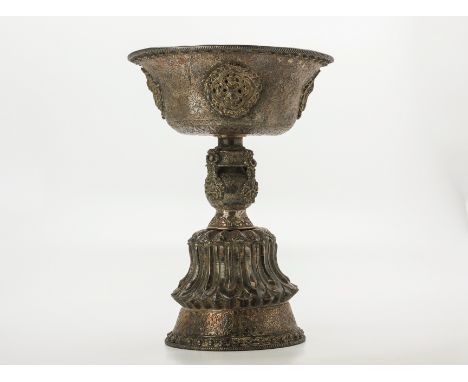 A TIBETAN SILVER BUTTER LAMP
The bowl with everted rim, applied with plaques of precious objects and with foliate engraved de