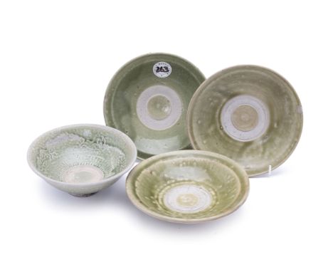 A GROUP OF FOUR VIETNAMESE GREEN GLAZED SHALLOW DISHES
Probably 14th C., with unglazed stacking rim to the centre, one with f