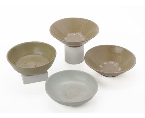 FOUR SMALL MONOCHROME GLAZED BOWLS A pair, with olive green glaze, conical with slightly everted rim, on flat foot rim, the i
