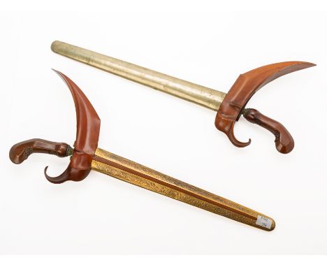 TWO SIMILAR INDONESIAN KRIS DAGGERS
Probably Java, with matching caved wood hilt, wavy blade and carved wood and metal scabba