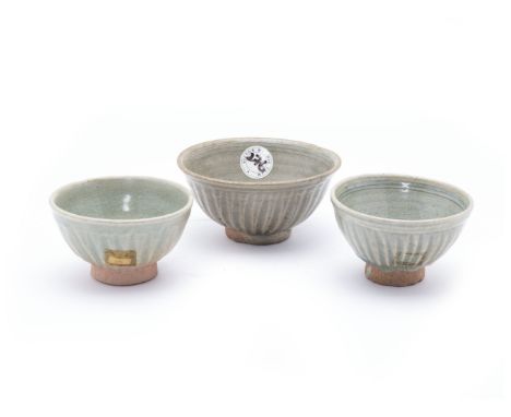 THREE THAI SAWANKHALOK CELADON GLAZED BOWLS
Likely 15th C., all of a similar design with fluted exterior on an unglazed sligh