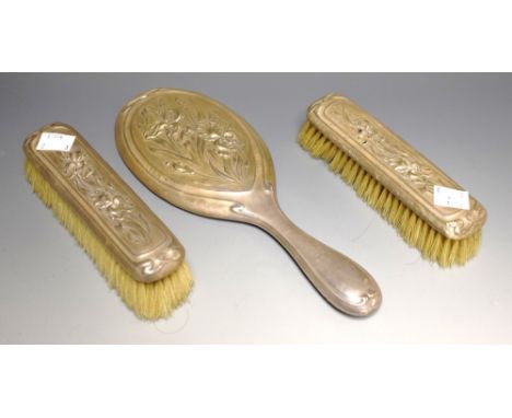An Edwardian Art Nouveau three piece brush set, embossed with flag irises, Birmingham 1905 