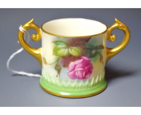 A Royal Worcester two-handled loving cup, painted with pink and yellow roses, the base in relief with stiff leaves, gilt scro