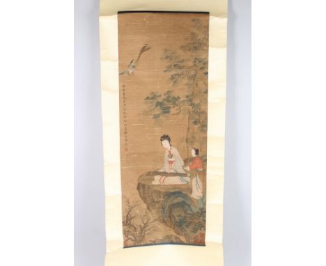 A CHINESE SCROLL PAINTING, depicting a female musician with attendant seated beneath a tree. 195cms long.