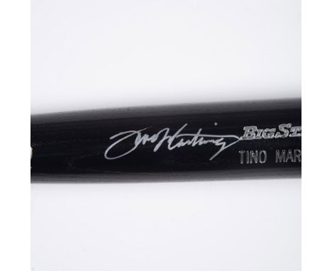 A black and natural wood colored bat stamped with silver marking it as a Tino Martinez Rawlings Big stick. Signed in silver s